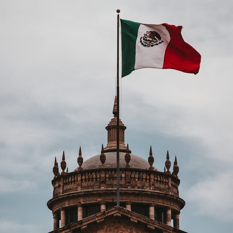 a mexican flag flying on top of a building